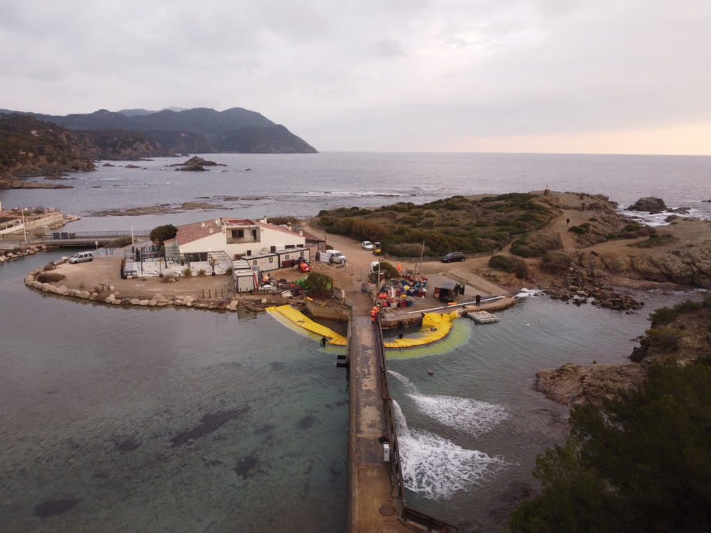 Vue aérienne du chantier de mise en assec au Gaou avec batardeaux souples et pompes rejetant l’eau d’infiltration depuis la passerelle.