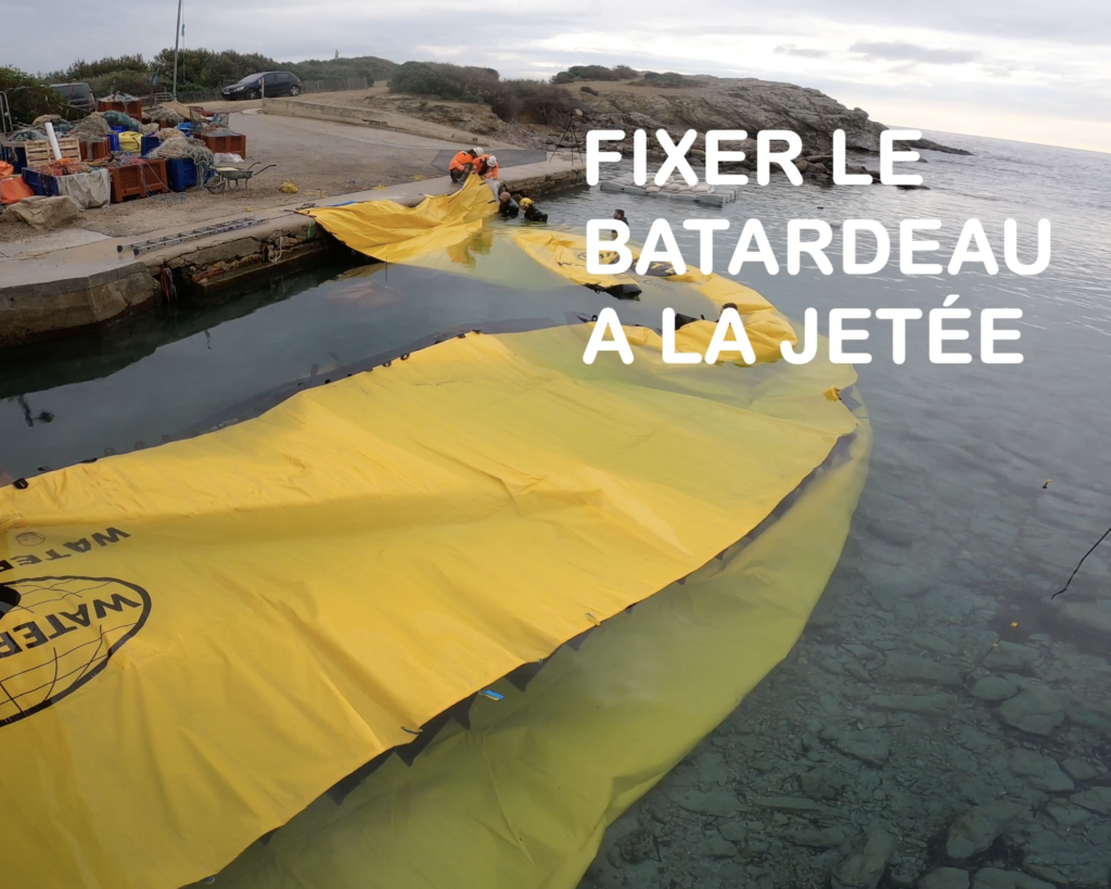 Fixation d’un batardeau souple contre un quai avec réserve de toile pour absorber les efforts lors de la mise en pression en milieu marin.