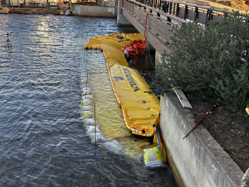 Vue depuis l’île du Gaou montrant le batardeau souple après pompage terminé au niveau nord de la passerelle en milieu marin.
