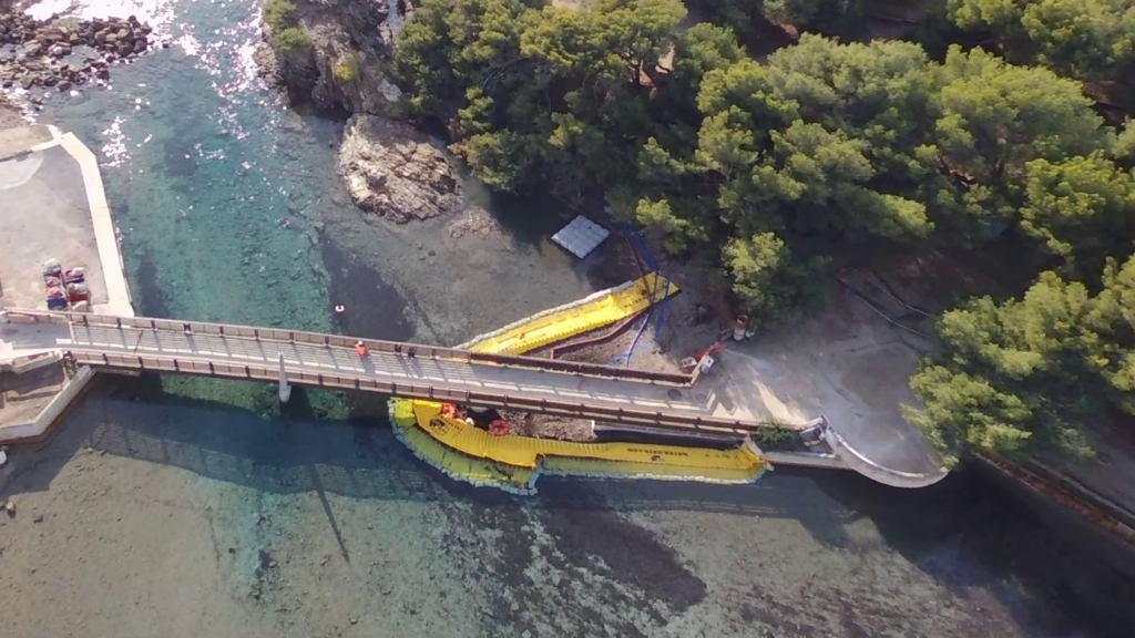 Vue drone du dispositif de batardeaux souples installé autour de la passerelle du Gaou pendant les travaux en lagune marine.